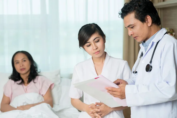 Doctor and his assistant discussing symptoms — Stock Photo, Image