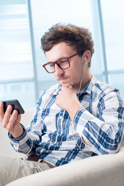 Homem usando smartphone com fones de ouvido — Fotografia de Stock