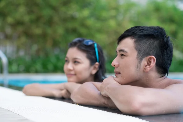Erkek ve kız arkadaşı havuz kenarında yaslanmış — Stok fotoğraf