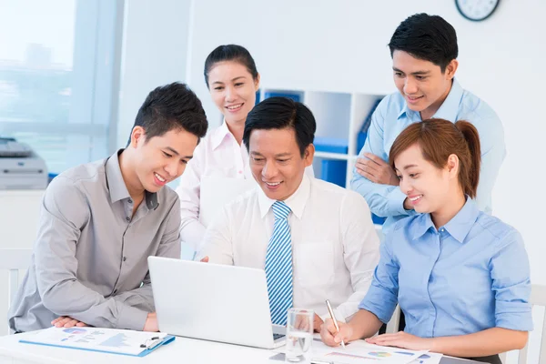 Equipe de negócios reunidos na frente do laptop — Fotografia de Stock