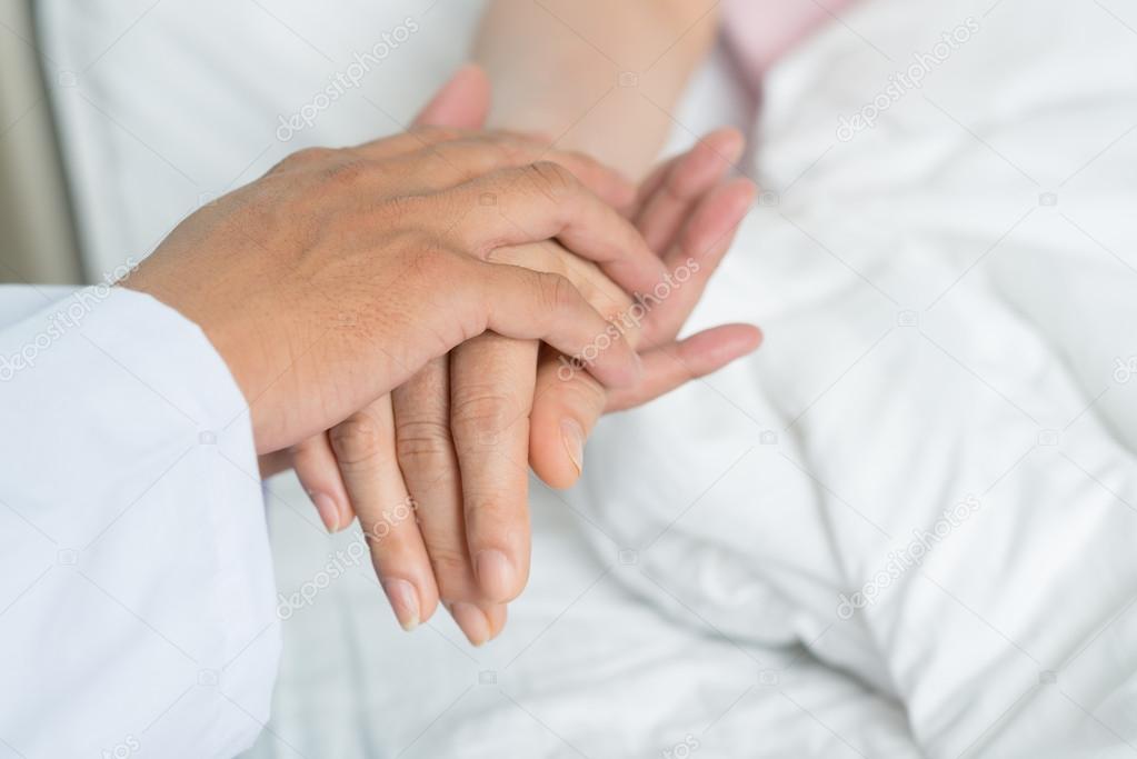 Doctor holding hand of the patient