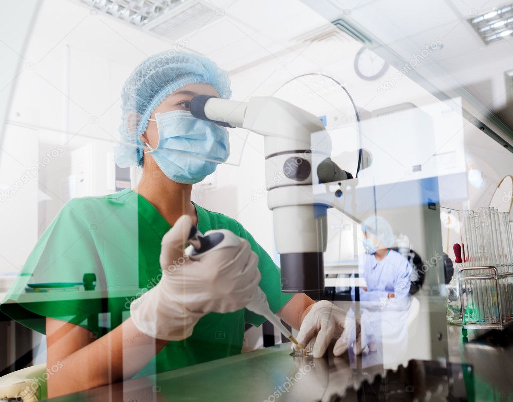 Asian scientist using microscope