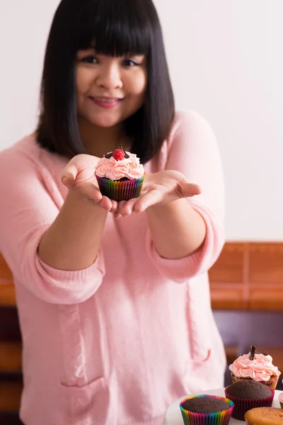 显示一个杯形蛋糕的年轻亚洲 — 图库照片