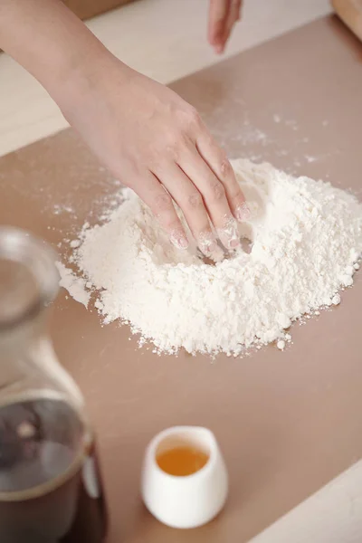 Mujer añadiendo yema de huevo a la harina — Foto de Stock