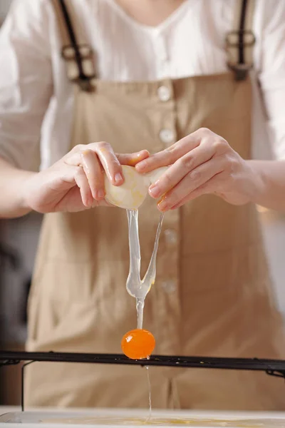 Женщина трещит соленое яйцо — стоковое фото