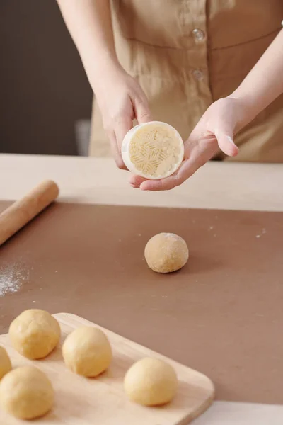 Mujer mostrando forma de pastel de luna de plástico — Foto de Stock