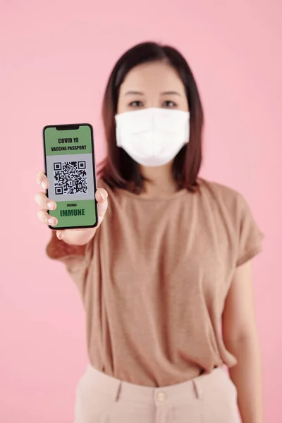 Vrouw in het medische masker toont QR-code — Stockfoto