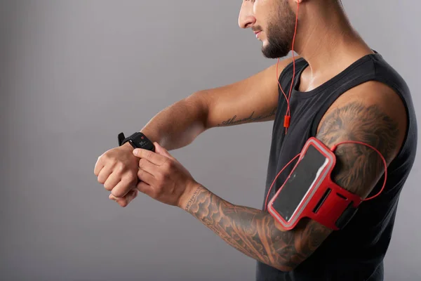 Uomo muscolare Checking Fitness Trekker — Foto Stock