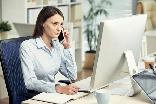 Занятая женщина-менеджер разговаривает по телефону в офисе — стоковое фото