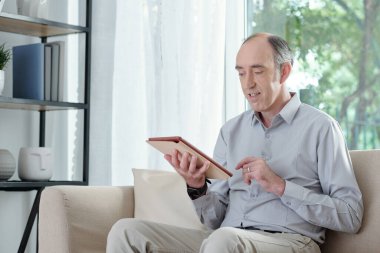 Gazete okuyan kıdemli adam.