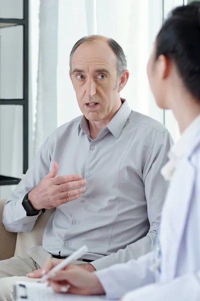 Hombre preocupante hablando con el médico general — Foto de Stock