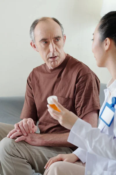 Homem discutindo analgésico com médico — Fotografia de Stock