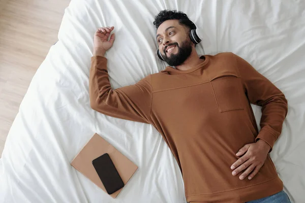 Mann mit Kopfhörer entspannt im Bett — Stockfoto