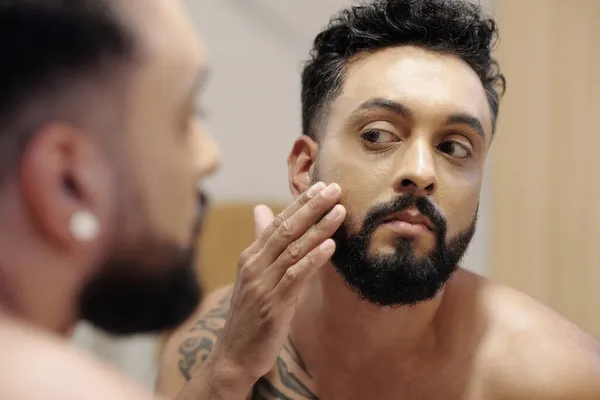 Homem bonito aplicando Loção Rosto — Fotografia de Stock