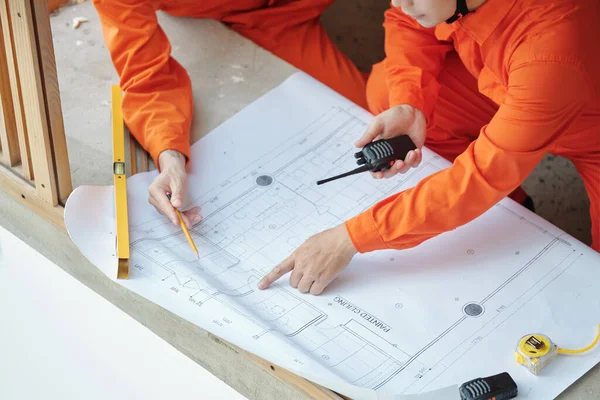 Trabalhadores da construção Apontando para o plano de construção — Fotografia de Stock