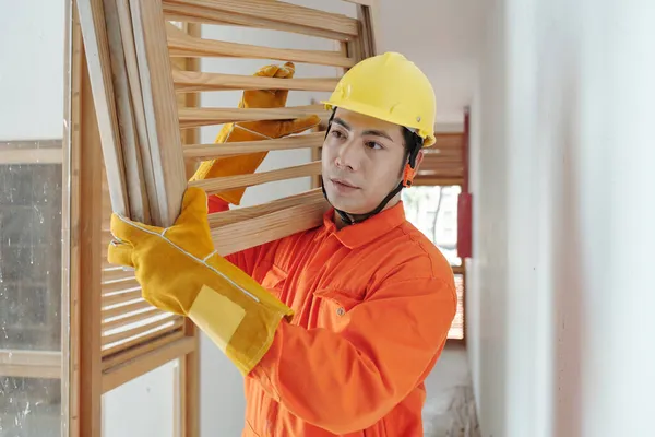 Travailleur de la construction portant des grilles en bois — Photo