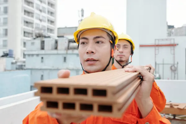 Travailleurs dans le transport de panneaux en bois lourds — Photo