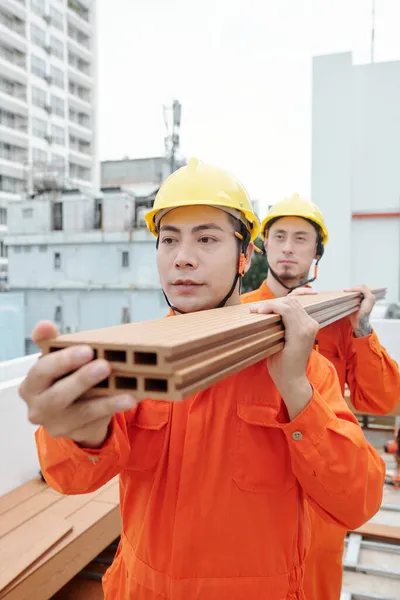 Byggare som bär trägolv — Stockfoto