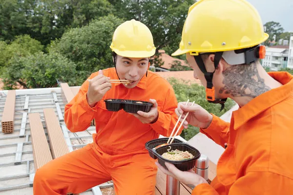 Byggare äter lunch på byggarbetsplatsen — Stockfoto