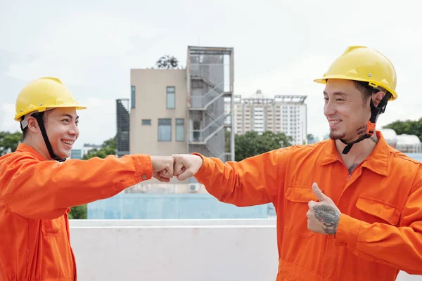 Trabajadores de la construcción dando un golpe de puño — Foto de Stock