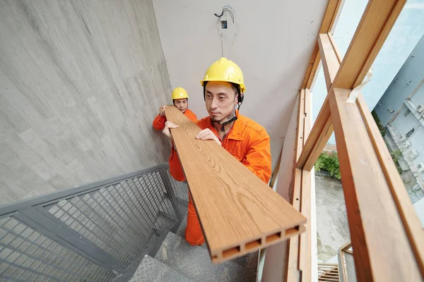 Trabalhadores da construção civil que transportam materiais de construção — Fotografia de Stock