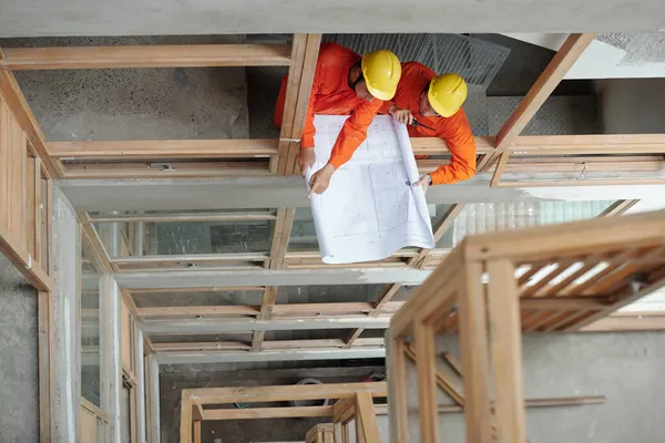 Trabalhadores da construção discutindo plano de casa — Fotografia de Stock