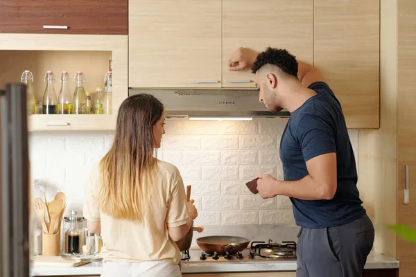 Curioso uomo guardando a cucina moglie — Foto Stock