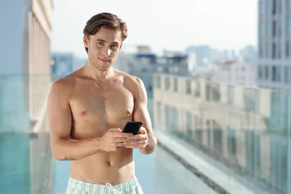 Muskulös ung man med smartphone — Stockfoto