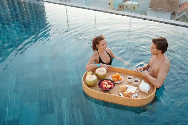 Casal tomando café da manhã na piscina ao ar livre — Fotografia de Stock