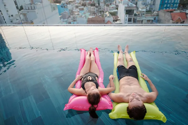 Paar hält Händchen beim Entspannen im Pool — Stockfoto