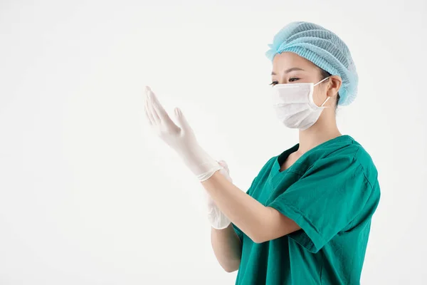 Enfermera poniéndose guantes de goma — Foto de Stock