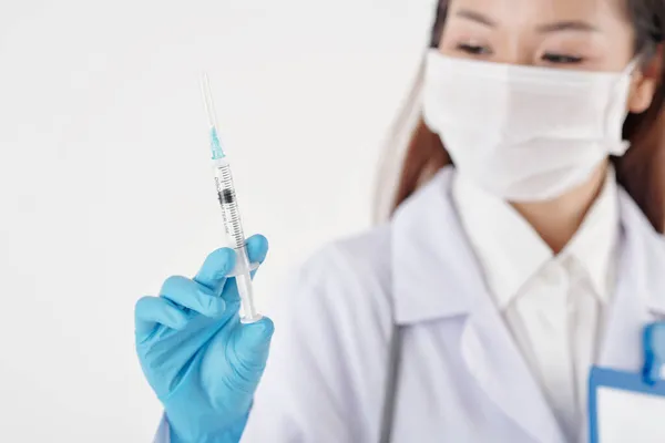 General Practitioner Looking at Syringe — Stock Photo, Image