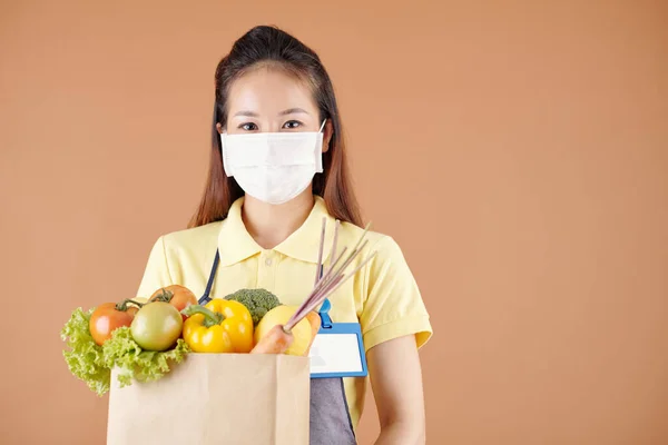 Frau hält Paket mit Lebensmitteln in der Hand — Stockfoto