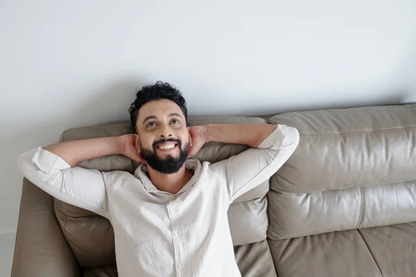 Glücklicher Mann sitzt auf bequemem Sofa — Stockfoto