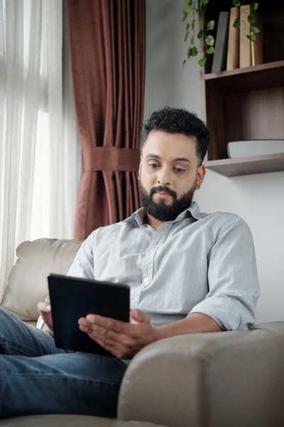 태블릿 컴퓨터에 책을 읽는 남자 — 스톡 사진