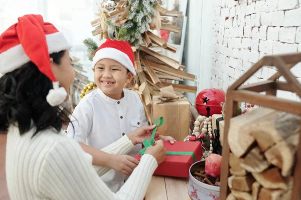 Çocuk Anne 'ye hediyeleri paketlemede yardım ediyor — Stok fotoğraf