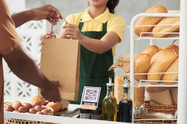 Bäckereiangestellte übergibt Paket an Kurier — Stockfoto