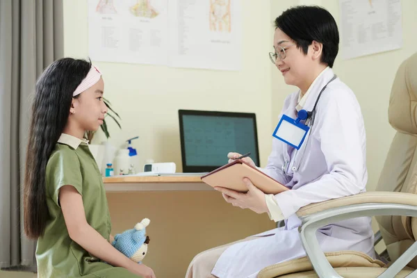 Pediatra escribiendo quejas de niña — Foto de Stock