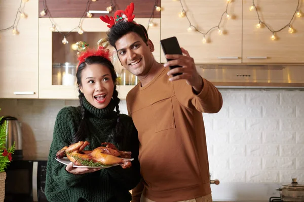 クリスマス料理とセルフィーを取るカップル — ストック写真