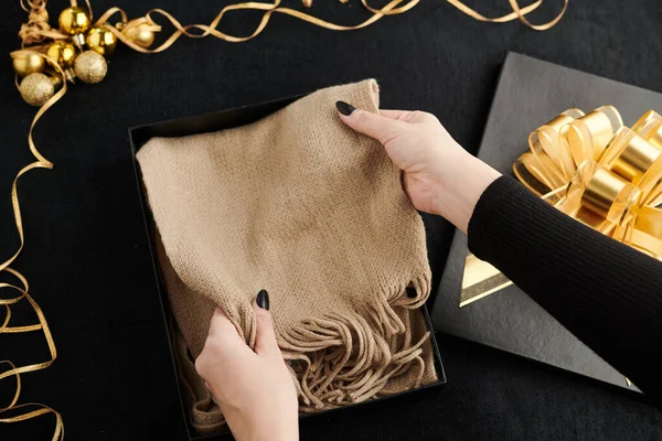 Mujer poniendo bufanda en caja de regalo — Foto de Stock