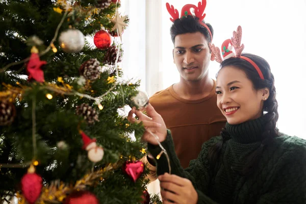 クリスマスツリーを飾るカップル — ストック写真