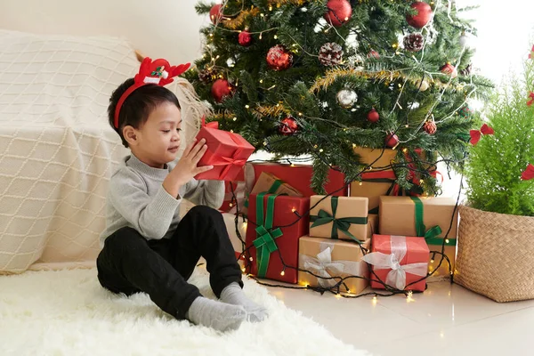 Junge öffnet Weihnachtsgeschenke — Stockfoto