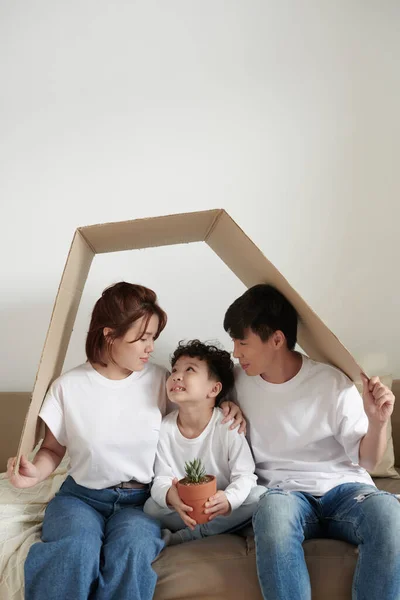 Radosna rodzina pod kartonowym dachem — Zdjęcie stockowe