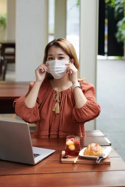 Businesswoman Taking off Mask in Cafe — Stockfoto