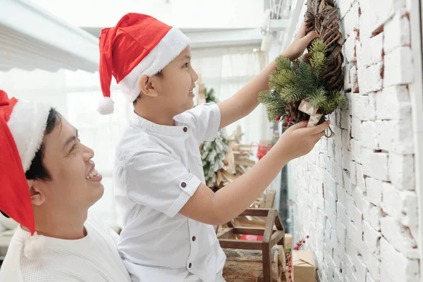 Father and Son Hanging Wreath on Wall — Stock Photo, Image