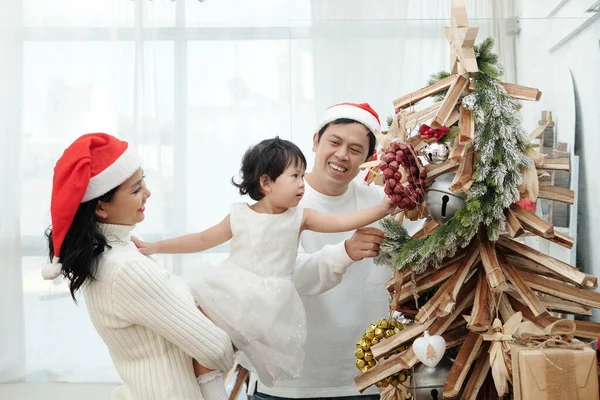 Familie schmückt Weihnachtsbaum — Stockfoto