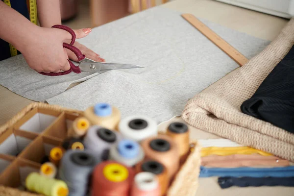 Seamstress Cutting Knitted Fabric