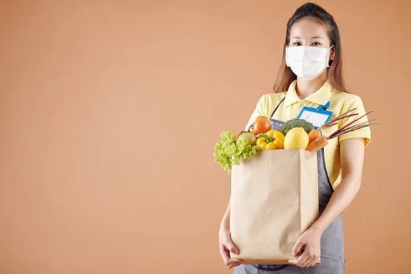 Supermarkt-Mitarbeiterin trägt Lebensmittel bei sich — Stockfoto