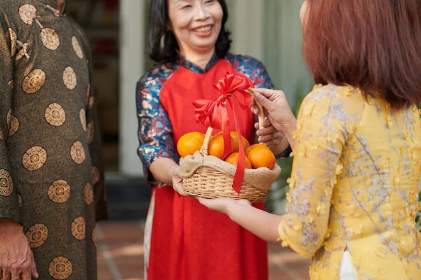 Dar mandarinas a pais seniores — Fotografia de Stock