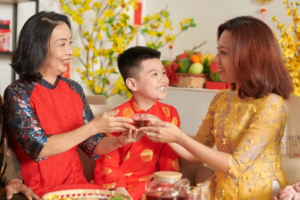 Donna che passa tazza di tè alla madre — Foto Stock